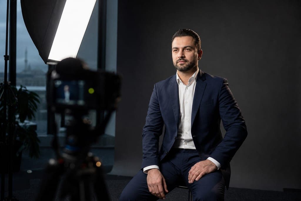 Korporativ portret çəkilişi — tünd fon, softbox işığı və əməkdaş portreti